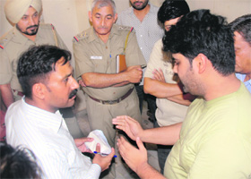 A UT health department official questions Navneet (left) regarding spurious dairy products seized from his residence in Sector 37, Chandigarh, on Friday.