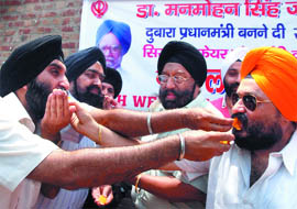Sikhs celebrate after Manmohan Singh took the Prime Ministers oath for the second time, at the Bangla Sahib Gurdwara in New Delhi on Friday.