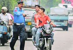 A cop tries to stop young traffic violators in Jammu.