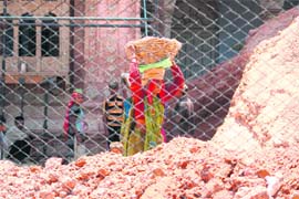 A woman labourer works under the scorching sun at the Mubarak Mandi complex, Jammu, where restoration work is going on in full swing.