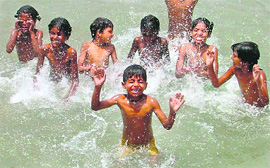 Children take a dip in Sidhwan Canal to beat the heat in Ludhiana on Friday.