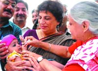 Delhi Chief Minister Sheila Dikshit and Delhi health minister Kiran Walia administer polio drops to a baby in New Delhi 