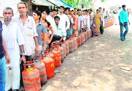 People line up outside a cooking gas agencys office to get their quota in Faridabad on Sunday