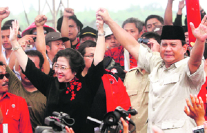 Former Indonesian President Megawati Sukarnoputri (L) and ex-General Prabowo Subianto raise their hands during a rally in Bantargebang, Bekasi, Jakarta, on Sunday.