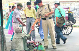 A policeman gives alms to a beggar in Dehradun on Monday.