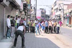 Children play cricket on a road as the roads remained deserted in Ludhiana