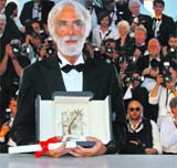 Director Michael Haneke waves on stage after receiving the Palme d'Or award for the film Das Weisse Band. 
