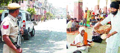 A policeman stands guard in the Hall Gate area and (right) a volunteer serves langar to the stranded passengers at the railway station in Amritsar.