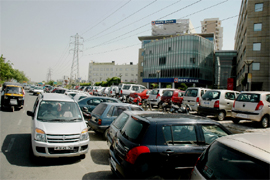 Vehicles parked on a busy road and adjoining footpath in the DLF area of Gurgaon on Tuesday.