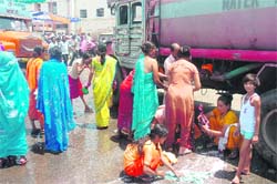 Stranded passengers take bath and wash clothes at Jammu railway station on Tuesday. 