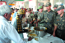Jawans of Vajra Corps serve food to the stranded passengers at Jalandhar Cantonment Railway station on Tuesday.