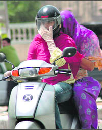 Two women try to protect themselves from the scorching sun in Gurgaon on Wednesday.