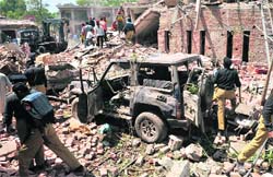 Policemen and rescuers search for victims in the rubble of a destroyed police building following the suicide car bomb attack in Lahore on Wednesday.