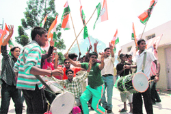 Congress workers celebrate the induction of Harish Rawat in the union council of ministers in Dehradun on Thursday.