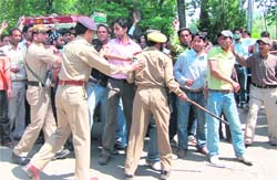 Policemen try to pacify students protesting against the death of a youth in an accident with an Army vehicle at Badami Bagh in Srinagar