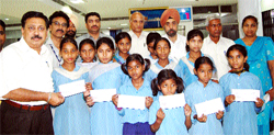 SBI officials distribute cheques among poor students of Nishkam Seva Public School in Amritsar.