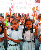 Schoolchildren with candles in hands pray for peace and harmony in Amritsar.