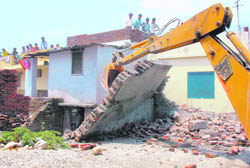 An anti-enroachment drive underway at Adhoiwala area in Dehradun on Friday. 