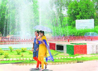 Girls pass by a fountain on the Jammu University campus.