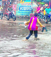 A girl wades through the water at Bhagat Singh Chowk.