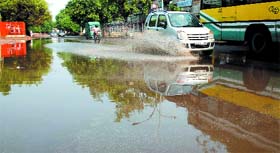Vehicles wade through rain water at Asaf Ali Road after heavy showers early in the morning in New Delhi