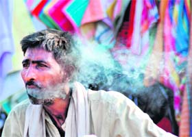 Oblivious of No Tobacco Day, a man smokes at a roadside shop in Karnal