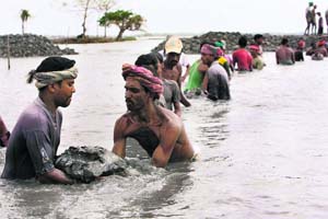 Bangladeshi villagers rebuild an embankment in Shatkhira, 176 km southwest of Dhaka, on Sunday