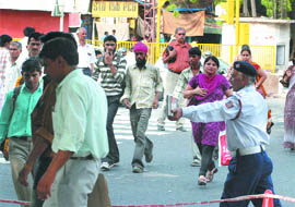 A Delhi traffic police officer shows pedestrians how to cross the road at ITO Crossing in New Delhi on Monday. The traffic police is observing 'Safe Pedestrian Week' from June 1.