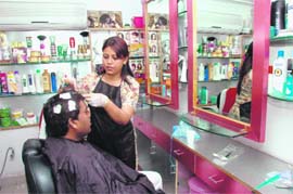 A young man gets a hair treatment at a saloon in Dehradun.