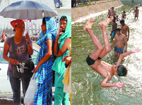 Girls use an umbrella to save themselves from scorching heat.  With temperature soaring, boys take a dip in a canal in Amritsar.