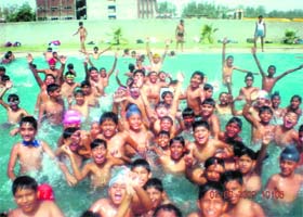 Schoolchildren enjoy themselves in the swimming pool during a summer camp at a school in Sirsa