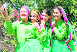 Girls from Mandi district taking pictures with their mobile phone camera after their performance on the first day of the summer festival at Shimla on Tuesday.