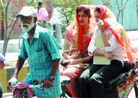 A dupatta comes to the rescue of girls on a rickshaw on a hot day in Jalandhar