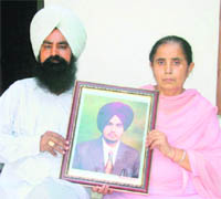  Maninderpal Singhs parents with his photograph.  Maninderpal died under mysterious circumstances in Australia last year.