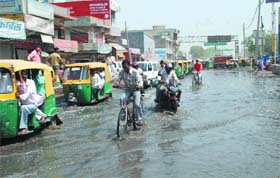 An overflowing drain floods a road in the Loni Border area in Ghaziabad