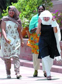 Employees of the Parliament House cover themselves with dupattas to escape the hot wind in New Delhi
