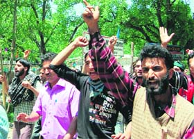 Youths shout slogans at Srinagar on Wednesday protesting the death of two women at Shopian a few days ago