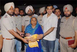 Bathinda SSP Ashish Chaudhary along with other police officials hands over the newly-born boy to his maternal grandmother Surjit Kaur at his residence late on Thursday night. The child had been missing from the Civil Hospital and was recovered by the police from Barnala.