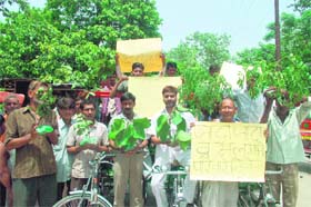 Activists of the Paryavaran Ekta Manch hold plant saplings as they paddle rickshaws near Birla Ghat in Haridwar