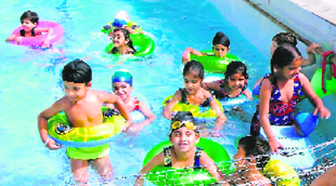Tiny tots beat the heat in a pool at Green Grove Public School in Ludhiana on Friday.