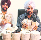 Jaskaran Singh (right), AIG, Counter Intelligence, Jalandhar (Zone), shows the heroin, currency and a pistol seized from smugglers at a press conference in Jalandhar on Friday.