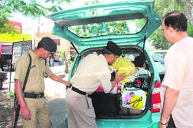 Policemen check a vehicle ahead of the IMA passing-out parade in Dehradun