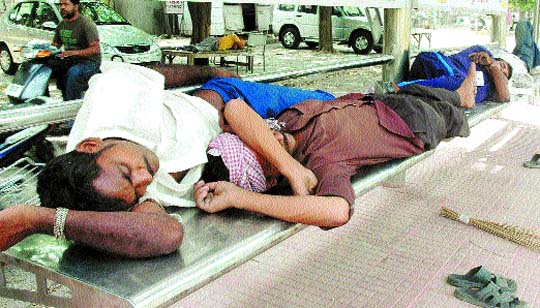 Labourers take a nap in a bus shelter on a hot day in Jalandhar