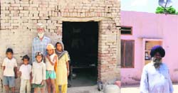 Tarsem Singh, a landless labourer of Melak Kangan village in Moga district, along with his family, outside his house. His name has not been included in the BPL list; (right) Sarpanch Sukhdev Singh, who has a four-room pucca house, has his name included in the list of beneficiaries of the Indira Awaas Yojna.