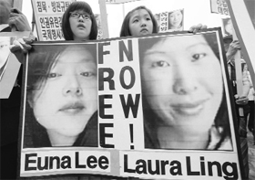 South Korean students hold photos of the detained US journalists during a rally in Seoul on Tuesday.