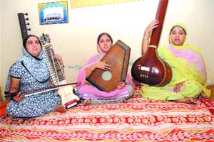 Sisters Poojapreet (L), Ashupreet (M) and Anupreet (R) rehearse a shabad at their home.