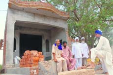 Residents of Chauke village in Bathinda at an under construction bus stop named after Chandigarh.