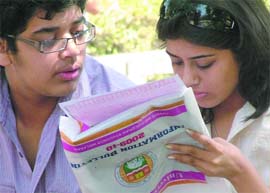 An admission seeker studies the admission form at Delhi University in New Delhi on Friday.