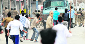 Agitators target a security vehicle during a protest over the Shopian incident in Srinagar on Friday.