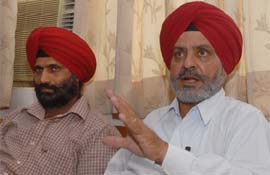 Officiating college principal Sukhdev Singh (left) and secretary of the Trust Hardev Singh speak to TNS